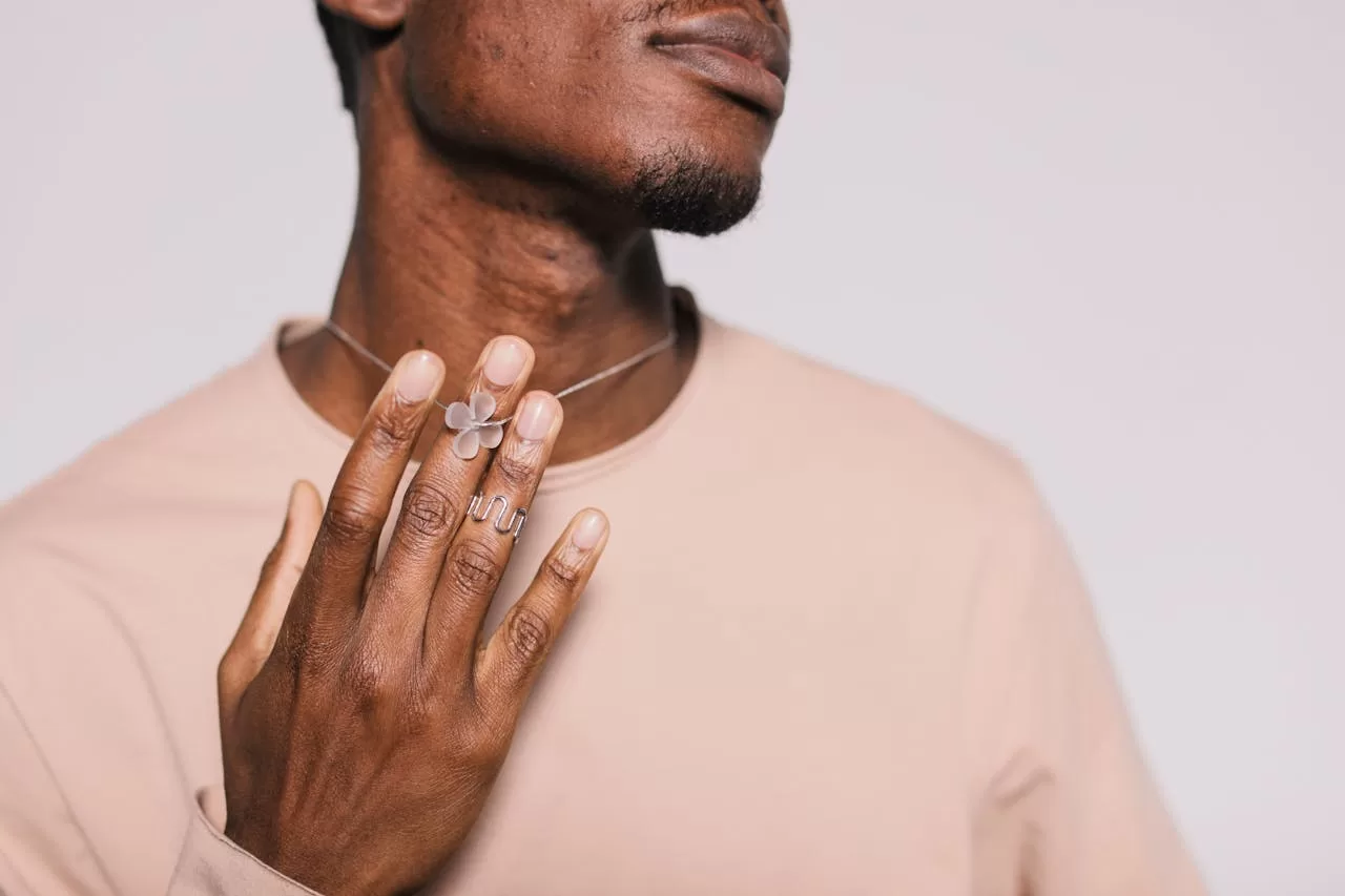 Homme qui porte un collier et une bague